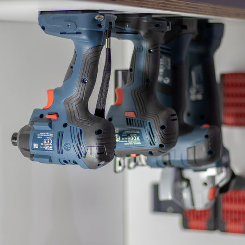 Bosch blauw professional machines hangend in gereedschaphouders onder een plank