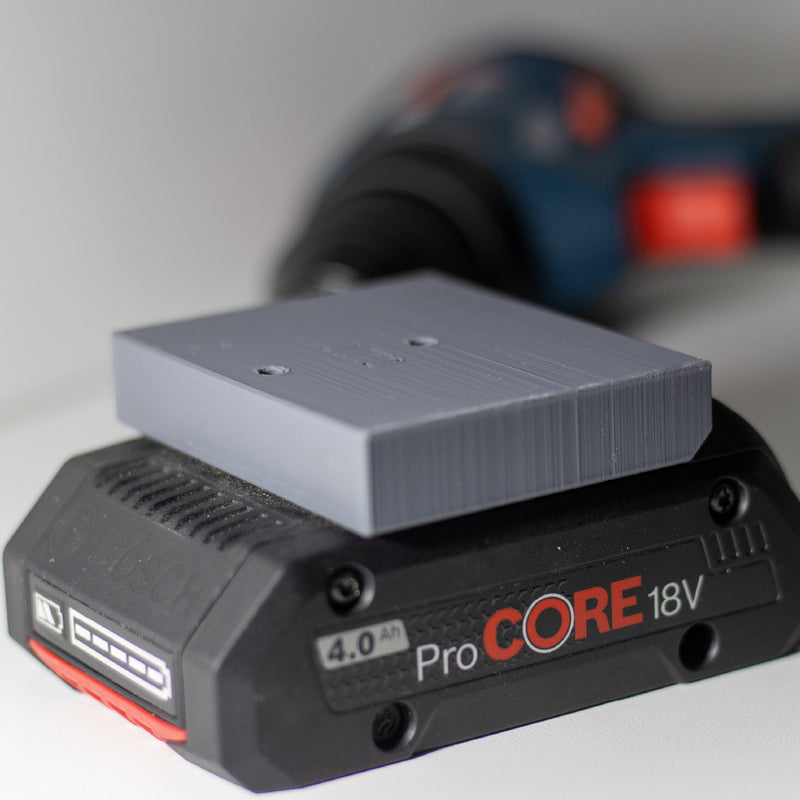 Houderplaat op een Bosch ProCORE 18V 4,0 Ah accu met machine op de achtergrond
