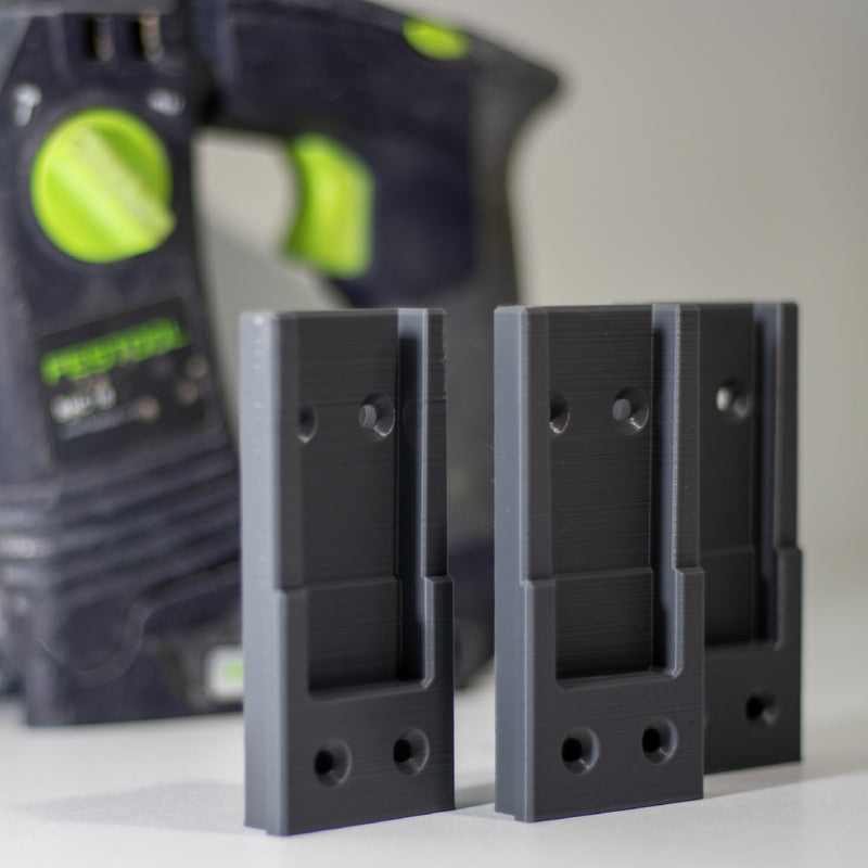 Drie Festool gereedschaphouders rechtop met een Festool decoupeerzaag erachter