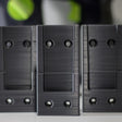 Drie donkergrijze Festool houders op een rij met een Festool machine op de achtergrond