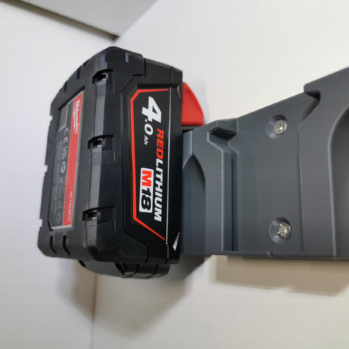 Milwaukee M18 4,0 Ah accu hangend in een accuhouder aan de muur