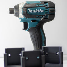 Makita slagschroevendraaier boven drie grijze wandhouders voor Makita LXT machines