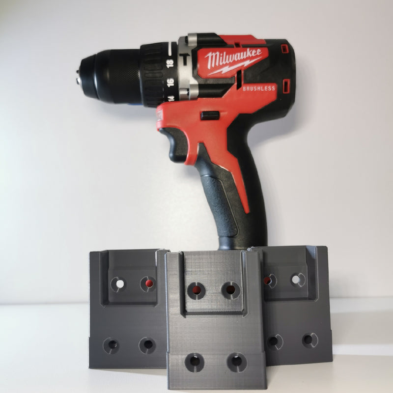 Milwaukee boormachine achter drie grijze Milwaukee gereedschaphouders