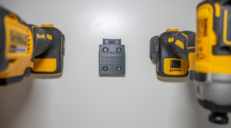 Lege DeWalt houder aan de muur tussen twee opgehangen DeWalt machines